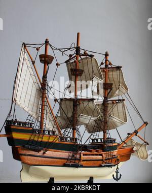 Modello in legno di una nave a vela con vele sulle falde su sfondo bianco per la storia verticale Foto Stock