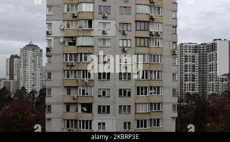 Alte e moderne case dietro un edificio a più piani fatto di vecchi mattoni di silicone Foto Stock