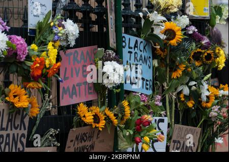 Fiori e cartelli vengono lasciati attaccati alle ringhiere della stazione della metropolitana di Westminster dopo che migliaia di persone transgender e i loro sostenitori hanno marciato attraverso il centro di Londra per celebrare la comunità dei Black Trans, commemorare le vittime dei Black Trans perse e protestare contro eventuali modifiche al Gender Recognition Act il 27 giugno, 2020 a Londra, Inghilterra. Il governo del Regno Unito sta progettando di eliminare le leggi di auto-identificazione proposte per le persone trans e non binary senza la necessità di diagnosi medica, nonostante la consultazione del governo sulla riforma del Gender Recognition Act showi Foto Stock