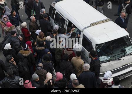 Un gruppo di persone Wrestling per ottenere un posto nel trasporto pubblico a Damasco, Siria il 2 ottobre 2019. Un progetto di documentazione che cattura una crisi socio-economica nell'era del dopoguerra in Siria, attraverso una serie di fotografie che raccontano la storia delle persone costrette a utilizzare i trasporti pubblici a Damasco, in quanto è l'unico metodo che si adatta al loro reddito. (Foto di Hasan Belal/NurPhoto) Foto Stock