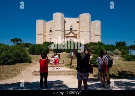 I visitatori che scattano foto ricordo e ammirano il Castel del Monte dall'esterno ad Andria il 1 luglio 2020. Castel del Monte ha riaperto ai visitatori il 1 luglio con turni scaglionati e con un numero limitato di persone in gruppo. Sono state adottate misure di sicurezza, distanza fisica, uso obbligatorio della maschera. Le guide turistiche non saranno in grado di svolgere il loro lavoro all'interno del Castello in quanto non ha ventilazione e di evitare riunioni ma solo all'esterno. (Foto di Davide Pischettola/NurPhoto) Foto Stock