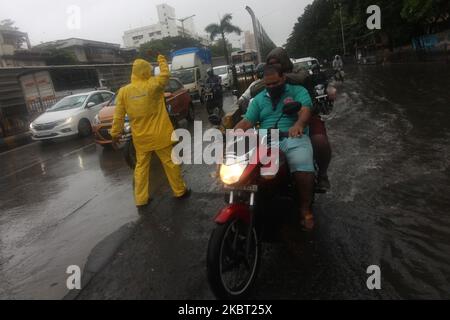 A policeman controls the traffic movement during heavy rains in Mumbai, India in Mumbai, India on July 03, 2020. Monsoon in India officially lasts from June to September. (Photo by Himanshu Bhatt/NurPhoto) Stock Photo