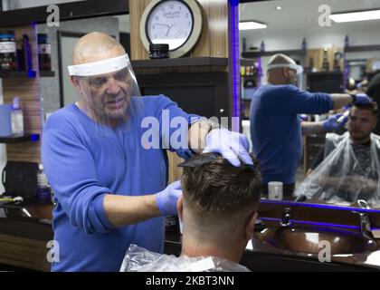 Un uomo che si taglia i capelli al MR Snips Barber Shop. Barbers' Shops e parrucchieri riaprono in tutta l'Inghilterra dopo essere stati chiusi da marzo a causa del blocco imposto dal governo britannico per contribuire a frenare la diffusione della pandemia COVID-19 a Stanford le Hope, Inghilterra il 4 luglio 2020. (Foto di Jacques Feeney/MI News/NurPhoto) Foto Stock