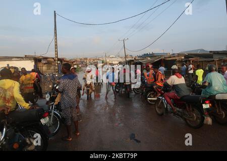 I motociclisti commerciali, conosciuti come i motociclisti di okada, arrestano il lavoro mentre l'alluvione prende sopra IgE Road, Aboru, Lagos. Alluvione sconvolse il movimento e le attività socio-economiche nella zona di Alabede di IgE Road, Aboru, Lagos, Nigeria dopo un pesante calo il 6 luglio 2020. (Foto di Adekunle Ajayi/NurPhoto) Foto Stock