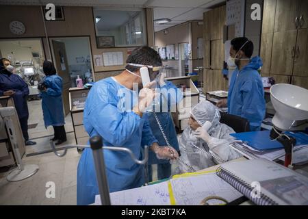 Il personale medico iraniano che indossa tute protettive parla al telefono mentre lavora in una sezione COVID-19 dell'ospedale Firoozabadi nel quartiere Shahre-Rey a sud di Teheran il 20 giugno 2020. (Foto di Morteza Nikoubazl/NurPhoto) Foto Stock