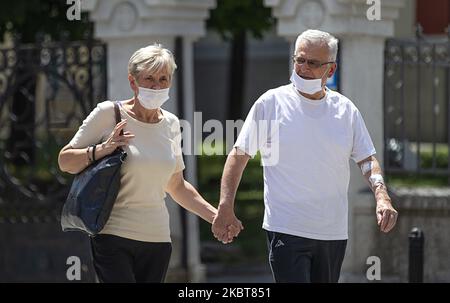 An elderly couple with masks walk through the city during the new Coronavirus Lockdown (COVID-19) after the increase of coronavirus infected in Belgrade, Serbia on July 8, 2020. The number of coronavirus infections is increasing throughout Serbia, especially in Belgrade, where 80% of coronavirus infections are found. The government mandates the mandatory use of masks indoors from this week and the president Aleksandar Vucic planned a curfew for the capital this weekend to halt the spread of the coronavirus disease (COVID-19). (Photo by Nikola Krstic/NurPhoto) Stock Photo