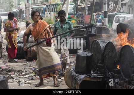 An woman worker prepares bitumen and rock mixtures to be used to repair a road in Dhaka, Bangladesh on July 10, 2020. (Photo by Ahmed Salahuddin/NurPhoto) Stock Photo