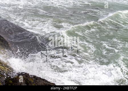 Tempesta ondate di picco che rompono le difese del mare. Tragumna, West Cork, Irlanda Foto Stock