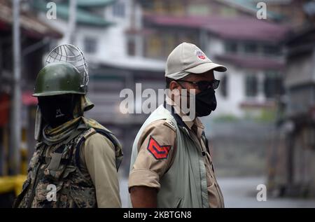 Il personale delle forze di sicurezza indiane si trova vicino a un punto di controllo temporaneo, mentre il blocco viene reimposto a Srinagar, Kashmir, il 13 luglio 2020. Le autorità hanno riimposto il blocco in molte aree della valle del Kashmir dopo l'impennata dei casi COVID-19 e l'aumento del tasso di mortalità. (Foto di Faisal Khan/NurPhoto) Foto Stock