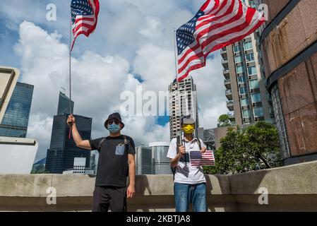 Due manifestanti posano con bandiere statunitensi su un ponte pedonale a poche centinaia di metri dal Consolato degli Stati Uniti a Hong Kong, Cina, il 4 luglio 2020. (Foto di Marc Fernandes/NurPhoto) Foto Stock