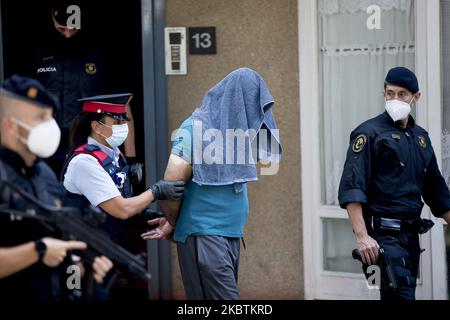 I membri della polizia regionale catalana Mossos d'Esquadra scortano un sospetto (C) durante un'operazione antiterrorismo a Barcellona, il 14 luglio 2020. (Foto di Albert Llop/NurPhoto) Foto Stock