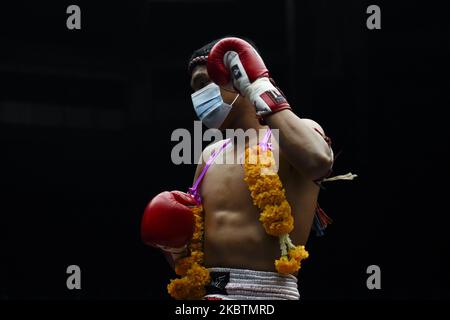 Un boxer Muaythai che indossa uno scudo facciale esegue la tradizionale danza Muay Thai prima della sua lotta davanti a posti a sedere vuoti dietro porte chiuse a causa della diffusione della malattia del coronavirus (COVID-19) allo stadio Rajadamnern di Bangkok, Thailandia, 15 giugno 2020. (Foto di Anusak Laowilas/NurPhoto) Foto Stock