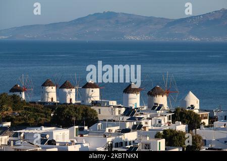 La mattina presto vista panoramica dei mulini a vento e della città di Mykonos, la panoramica è vista da una collina. I mulini iconici dell'isola di Mykonos, le isole Cicladi, il Mar Egeo, la Grecia il 14 luglio 2020. Ci sono 16 mulini a vento sull'isola, 5 dei quali sopra Chora o Mykonos Town, la città principale dell'isola. I mulini a vento sono stati costruiti nel 16th ° secolo dai veneziani, ma le loro costruzioni continuarono fino al 20th ° secolo. La famosa isola greca mediterranea è soprannominata l'Isola dei Venti con edifici tradizionali imbiancati come mulini a vento o chiesetta. Mykonos è un'isola molto popolare Foto Stock