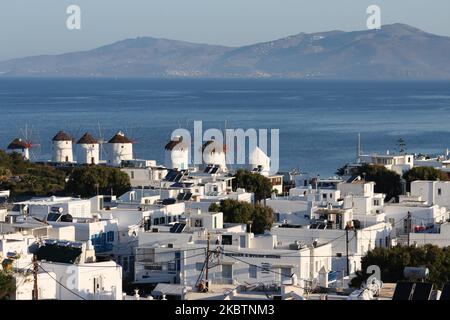 La mattina presto vista panoramica dei mulini a vento e della città di Mykonos, la panoramica è vista da una collina. I mulini iconici dell'isola di Mykonos, le isole Cicladi, il Mar Egeo, la Grecia il 14 luglio 2020. Ci sono 16 mulini a vento sull'isola, 5 dei quali sopra Chora o Mykonos Town, la città principale dell'isola. I mulini a vento sono stati costruiti nel 16th ° secolo dai veneziani, ma le loro costruzioni continuarono fino al 20th ° secolo. La famosa isola greca mediterranea è soprannominata l'Isola dei Venti con edifici tradizionali imbiancati come mulini a vento o chiesetta. Mykonos è un'isola molto popolare Foto Stock