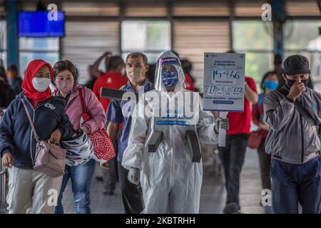 Un dipendente che indossa indumenti protettivi come precauzione contro il nuovo coronavirus tiene un banner che mostra informazioni sul virus e su quelli infetti presso la stazione centrale degli autobus Harmoni di Giacarta, Indonesia, il 17 luglio 2020. L’Indonesia ha il numero più alto di infezioni da coronavirus e di decessi nel sud-est asiatico. Secondo il funzionario del ministero della sanità, nelle ultime 24 ore nove province hanno registrato un numero elevato di casi. il presidente indonesiano, Joko Widodo, ha invitato il pubblico ad obbedire ai protocolli sanitari attuati per evitare ulteriori infezioni da COVID-19. (Foto di Afriadi Hi Foto Stock