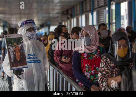 Un dipendente che indossa indumenti protettivi come precauzione contro il nuovo coronavirus tiene un banner che mostra informazioni sul virus e su quelli infetti presso la stazione centrale degli autobus Harmoni di Giacarta, Indonesia, il 17 luglio 2020. L’Indonesia ha il numero più alto di infezioni da coronavirus e di decessi nel sud-est asiatico. Secondo il funzionario del ministero della sanità, nelle ultime 24 ore nove province hanno registrato un numero elevato di casi. il presidente indonesiano, Joko Widodo, ha invitato il pubblico ad obbedire ai protocolli sanitari attuati per evitare ulteriori infezioni da COVID-19. (Foto di Afriadi Hi Foto Stock