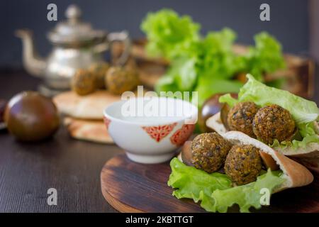 Pita e falafel - cibo orientale su un tavolo di legno Foto Stock