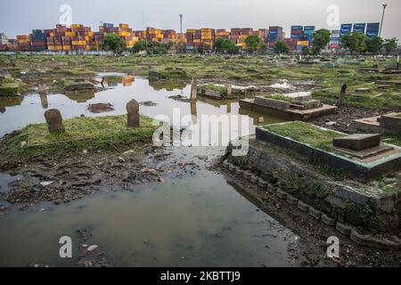 Una vista del cimitero pubblico che sommerse dalle acque di alluvione dall'aumento del livello del mare il 18 luglio 2020 a Giacarta Nord, Indonesia. Dagli anni '1970s, alcune parti di Giacarta sono affondate per più di quattro metri, ad una velocità fino a 25 centimetri l'anno. La capitale indonesiana di Giacarta ospita 10 milioni di persone, ma è anche una delle città più affondate al mondo. Circa il 40% di Giacarta si trova sotto il livello del mare. (Foto di Afriadi Hikmal/NurPhoto) Foto Stock