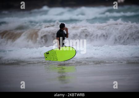 Un surfista porta con sé una piccola tavola mentre guarda le onde il 19 luglio 2020 a Warriewood Beach a Sydney, Australia. (Foto di Izhar Khan/NurPhoto) Foto Stock