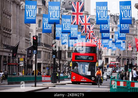 A bus passes underneath 'Thank You' banners in the colours of the National Health Service, and Union Jack flags, on Regent Street in London, England, on July 22, 2020. UK retail sales data for June, during which non-essential shops were allowed to reopen, is set to be released by the Office for National Statistics (ONS) this Friday, July 24. The day will also be the first that people in England will be required to wear face masks or other kinds of face covering in shops and supermarkets. Face coverings on public transport have been compulsory across England since mid-June. (Photo by David Clif Stock Photo