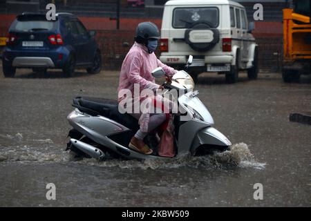 La gente indiana guida attraverso una strada allagata durante una pioggia pesante Monsoon a Ajmer, Rajasthan, India il 24 luglio 2020. (Foto di Himanshu Sharma/NurPhoto) Foto Stock