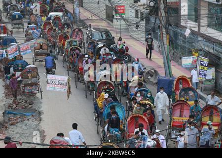 La gente sta cavalcando sui risciò a Dhaka, Bangladesh il 25 luglio 2020. (Foto di Rehman Asad/NurPhoto) Foto Stock