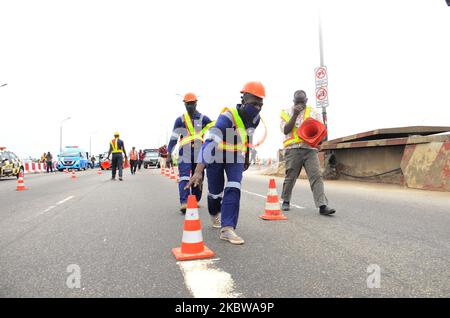 I lavoratori edili organizzano le barricate sulla strada mentre i lavori di riparazione in corso inizieranno sul terzo ponte continentale, il 26 luglio 2020, a Lagos. Nigeria, in particolare tra i periodi di punta del 6,30am e del 7pm, poiché molti più passeggeri saranno invitati a viaggiare attraverso rotte alternative e i corsi d'acqua, mentre la chiusura parziale del terzo ponte continentale di Lagos dura. (Foto di Olukayode Jaiyeola/NurPhoto) Foto Stock