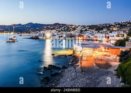 Ora magica durante il tramonto e il crepuscolo a Little Venice sull'isola di Mykonos, uno dei luoghi più romantici dell'isola mediterranea il 14 luglio 2020. Questo quartiere è pieno di eleganti e splendide vecchie case situate precariosamente ai margini del Mar Egeo, colorati edifici in stile veneziano a due piani con balconi in legno. Questi edifici ospitano adesso bar alla moda, ristoranti, gallerie e molto altro, ma il loro esterno e' ancora uno dei piu' popolari punti del tramonto, la classica romantica esperienza di Mykonos. La famosa isola delle Cicladi è soprannominata isola del Wi Foto Stock