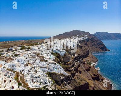 Foto panoramica aerea del pittoresco villaggio mediterraneo tradizionale di Oia, famoso in tutto il mondo, nell'isola vulcanica di Santorini, nelle Cicladi del Mar Egeo in Grecia. L'isola è famosa per il magico tramonto, l'architettura delle case imbiancate, gli hotel con vista sulla piscina e le chiese a cupola blu sul bordo ripido della scogliera. Santorini è una destinazione popolare per la luna di miele, proposte, matrimoni e coppie da tutto il mondo, ma di solito è sovraffollata di turisti asiatici come è considerato uno dei migliori luoghi romantici del mondo. Le autorità greche hanno revocato il Covi Foto Stock