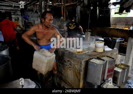 I lavoratori portano il tofu per essere imballato in una piccola industria di tofu nella zona di Duren Tiga, a sud di Giacarta, nell'agosto 2,2020. Durante la pandemia del covid-19 il micro-tofu che fa il commercio su piccola scala non ha avvertito un declino ed è stato collegato soltanto alla lenta importazione di soia importata che è venuto con esso. Il governo indonesiano ha erogato il bilancio per il programma nazionale di ripresa economica per le cooperative destinate alle piccole imprese, raggiungendo 11,84 miliardi di IDR per contribuire al buon andamento delle imprese. (Foto di Dasril Roszandi/NurPhoto) Foto Stock