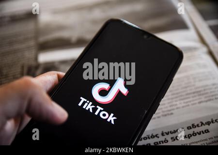 Logo TikTok closeup visualizzato sullo schermo di uno smartphone e il giornale locale di la Canea, isola di Creta, Grecia il 3 agosto 2020. Il presidente degli Stati Uniti Donald Trump sta minacciando e pianificando di vietare la popolare applicazione di condivisione video TikTok dagli Stati Uniti a causa del rischio per la sicurezza. (Foto Illustrazione di Nikolas Kokovlis/NurPhoto) Foto Stock
