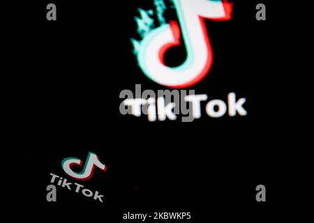 Logo TikTok closeup visualizzato sullo schermo di uno smartphone e un altro logo TikTok come sfondo su uno schermo TV a Chania, Isola di Creta, Grecia il 3 agosto 2020. Il presidente degli Stati Uniti Donald Trump sta minacciando e pianificando di vietare la popolare applicazione di condivisione video TikTok dagli Stati Uniti a causa del rischio per la sicurezza. (Foto di Nikolas Kokovlis/NurPhoto) Foto Stock