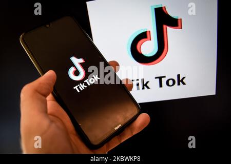 Logo TikTok closeup visualizzato sullo schermo di uno smartphone e un altro logo TikTok come sfondo su uno schermo TV a Chania, Isola di Creta, Grecia il 3 agosto 2020. Il presidente degli Stati Uniti Donald Trump sta minacciando e pianificando di vietare la popolare applicazione di condivisione video TikTok dagli Stati Uniti a causa del rischio per la sicurezza. (Foto di Nikolas Kokovlis/NurPhoto) Foto Stock