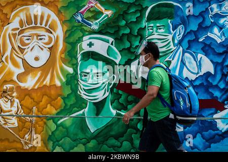 Un uomo passa davanti a un murale raffigurante frontliner a Pasig City, Filippine, il 4 agosto 2020. Metro Manila e altre quattro province ritornano alla quarantena comunitaria migliorata modificata (MECQ), poiché i casi confermati di COVID-19 nel paese continuano ad aumentare. Anche le operazioni di treni, autobus e altri mezzi di trasporto pubblico sono state sospese.(Foto di Lisa Marie David/NurPhoto) Foto Stock