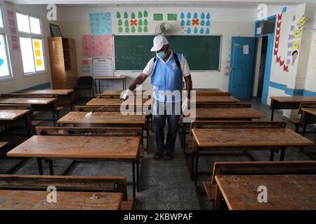 Un operaio palestinese che indossa una maschera protettiva igienizza un'aula scolastica in una scuola gestita dalle Nazioni Unite prima dell'inizio di un nuovo anno accademico, in mezzo alle preoccupazioni circa la diffusione della malattia di coronavirus (COVID-19), a Gaza City, in Palestina il 5 agosto 2020. (Foto di Majdi Fathi/NurPhoto) Foto Stock