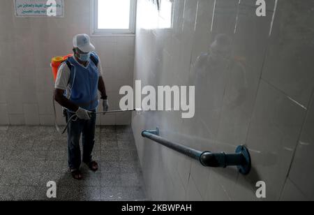 Un operaio palestinese che indossa una maschera protettiva igienizza in una scuola gestita dalle Nazioni Unite prima che inizi un nuovo anno accademico, in mezzo alle preoccupazioni circa la diffusione della malattia di coronavirus (COVID-19), a Gaza City, Palestina il 5 agosto 2020. (Foto di Majdi Fathi/NurPhoto) Foto Stock