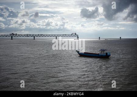 Una vista del ponte polifunzionale strada-ferrovia Padma attraverso il fiume Padma è in costruzione vicino a Dhaka, Bangladesh Domenica, 09 agosto 2020. Padma Bridge è il progetto di costruzione più impegnativo nella storia del Bangladesh. Il ponte a due piani, in acciaio, porterà un'autostrada a quattro corsie al livello superiore e una ferrovia a binario unico al livello inferiore, che sarà il ponte più grande dei bacini fluviali Padma-Brahmaputra-Meghna del paese, sia in termini di estensione che di lunghezza totale. (Foto di Syed Mahamudur Rahman/NurPhoto) Foto Stock