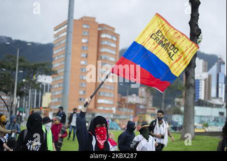 Un dimostratore sventola una bandiera colombiana con vernice rossa che assomiglia al sangue con il messaggio "il governo è criminale" che beve le demosntrazioni contro il governo del presidente Ivan Duque durante il giorno commemorativo della battaglia di Boyaca il 7 2020 agosto a Bogotà, in Colombia. (Foto di Sebastian Barros/NurPhoto) Foto Stock