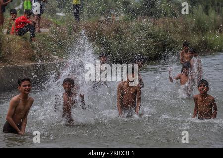 I ragazzi di Kashmiri si raffreddano in un ruscello per battere il calore in una calda giornata estiva nella città di Sopore del distretto di Baramulla, circa 60Kms km da Srinagar a Jammu e Kashmir, India il 13 agosto 2020. Srinagar registra 35,4 gradi celsius; tempo per rimanere caldo, umido per la prossima settimana (Foto di Nasir Kachroo/NurPhoto) Foto Stock