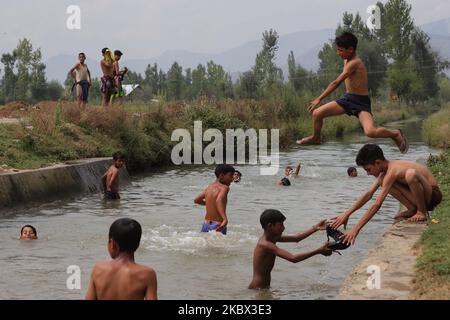 I ragazzi di Kashmiri si raffreddano in un ruscello per battere il calore in una calda giornata estiva nella città di Sopore del distretto di Baramulla, circa 60Kms km da Srinagar a Jammu e Kashmir, India il 13 agosto 2020. Srinagar registra 35,4 gradi celsius; tempo per rimanere caldo, umido per la prossima settimana (Foto di Nasir Kachroo/NurPhoto) Foto Stock