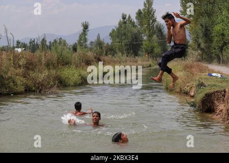 I ragazzi di Kashmiri si raffreddano in un ruscello per battere il calore in una calda giornata estiva nella città di Sopore del distretto di Baramulla, circa 60Kms km da Srinagar a Jammu e Kashmir, India il 13 agosto 2020. Srinagar registra 35,4 gradi celsius; tempo per rimanere caldo, umido per la prossima settimana (Foto di Nasir Kachroo/NurPhoto) Foto Stock