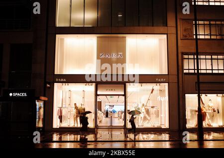 Le donne che si riparano sotto gli ombrelli passano davanti a una filiale del rivenditore di abbigliamento Zara su Oxford Street dopo un downpour notturno a Londra, Inghilterra, il 14 agosto 2020. (Foto di David Cliff/NurPhoto) Foto Stock