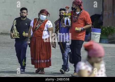 Una famiglia entra nel tempio di San Simón a San Andrés Itzapa, 50 chilometri a ovest della capitale del Guatemala, il 14 agosto 2020. Migliaia di persone credono che il santo che aiuta le persone a trovare lavoro, risolve i problemi familiari e cura le malattie. Durante la pandemia, il tempio fu chiuso per prevenire il contagio, con un totale di 61.428 persone infette e 2.341 morti in tutto il paese. (Foto di Deccio Serrano/NurPhoto) Foto Stock