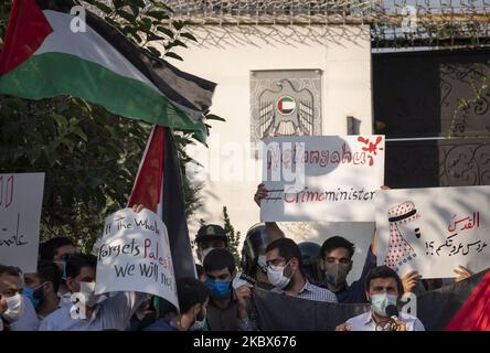 I manifestanti iraniani hanno fatto sventolare una bandiera palestinese e hanno un cartello mentre assistono a un incontro di protesta di fronte all'ambasciata degli Emirati Arabi Uniti a Teheran nord-occidentale, il 15 agosto 2020. Un gruppo di studenti iraniani dell’Università di Teheran si riunisce di fronte all’ambasciata degli Emirati Arabi Uniti per manifestare la propria protesta contro le relazioni diplomatiche tra Emirati Arabi Uniti e Israele. (Foto di Morteza Nikoubazl/NurPhoto) Foto Stock