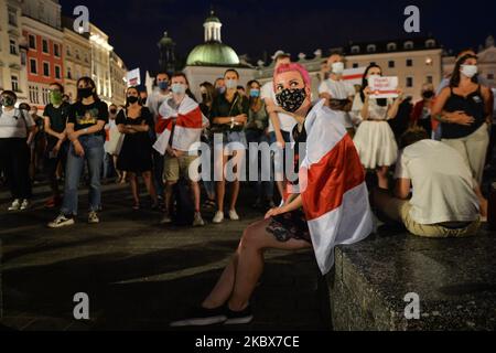 Manifestanti visti nella piazza principale del mercato di Cracovia. I membri della diaspora locale bielorussa, gli attivisti e i sostenitori locali si sono nuovamente stuaccati sabato sera per esprimere la loro solidarietà con i bielorussi durante il Rally di solidarietà organizzato a Cracovia. Il 15 agosto 2020, a Cracovia, Polonia. (Foto di Artur Widak/NurPhoto) Foto Stock