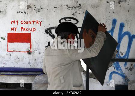 Bambang continua a dipingere una pocaratteristica del Padre fondatore indonesiano, Sukarno, presso il suo studio di pittura di strada durante la celebrazione del 75th° giorno dell'indipendenza dell'Indonesia a Giacarta, Indonesia, il 17 agosto 2020. Bambang Tridoyo (63), artista di pittura di strada. Ha iniziato la sua carriera dal 1975. In qualità di ammiratore del Padre fondatore dell'Indonesia, Sukarno, molte delle opere di Bambang sono ispirate da storie e figure eroiche. Non solo vendendo i suoi dipinti, accetta anche i servizi di pittura ritratto per i suoi clienti. La pandemia di Covid-19 che ha colpito l'Indonesia dalla fine di febbraio 2020 ha avuto un significativo Foto Stock