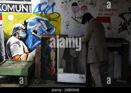 Bambang, si prepara ad aprire il suo studio di pittura di strada durante la celebrazione del 75th° giorno dell'indipendenza dell'Indonesia a Giacarta, Indonesia, il 17 agosto 2020. Bambang Tridoyo (63), artista di pittura di strada. Ha iniziato la sua carriera dal 1975. In qualità di ammiratore del Padre fondatore dell'Indonesia, Sukarno, molte delle opere di Bambang sono ispirate da storie e figure eroiche. Non solo vendendo i suoi dipinti, accetta anche i servizi di pittura ritratto per i suoi clienti. La pandemia del Covid-19 che ha colpito l'Indonesia dalla fine di febbraio 2020 ha avuto un impatto significativo sul suo reddito, soprattutto dopo il governo i. Foto Stock