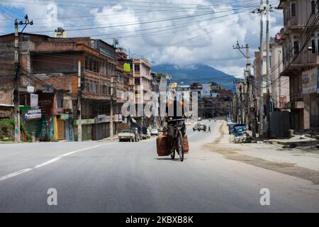 Un uomo di consegna di bombole di gas che indossa uno scudo facciale cavalca su una strada deserta dopo che il governo ha riimposto il blocco per una settimana come misura preventiva contro la diffusione del coronavirus COVID-19 a Kathmandu, Nepal il 20 agosto 2020. (Foto di Rojan Shrestha/NurPhoto) Foto Stock