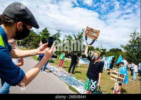 Un uomo sta scattando una foto di un attivista che tiene un cartello contro la moda veloce, durante la manifestazione "libertà per gli uiguri" a l'Aia, nei Paesi Bassi, il 20th agosto 2020. (Foto di Romy Arroyo Fernandez/NurPhoto) Foto Stock