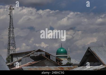 Tomba di una moschea (Masjid) insieme alle torri del cellulare sono viste nella città di Sopore del distretto Baramulla, Jammu e Kashmir, India il 21 agosto 2020. La connessione Internet ad alta velocità 4G è stata ripristinata domenica tarda nel distretto centrale di Ganderbal nel Kashmir e a Udhampur a Jammu su base trial fino al settembre 8, ponendo fine a un periodo di blackout di un anno dall'annullamento dell'articolo 370. (Foto di Nasir Kachroo/NurPhoto) Foto Stock